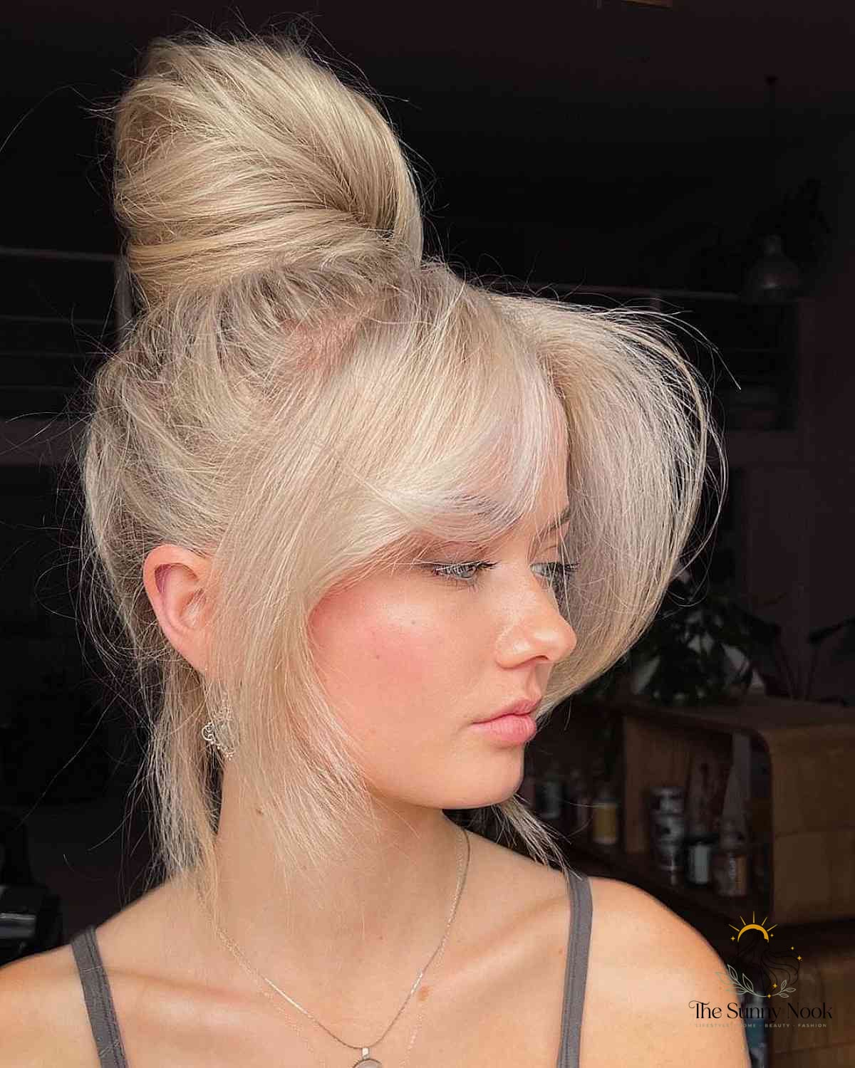 27 Slick Bun Hairstyles We're Obsessed With Right Now 8 Champagne Blonde Messy Top Knot