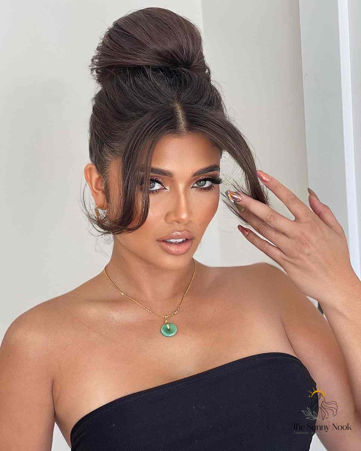 27 Slick Bun Hairstyles We're Obsessed With Right Now 5 Elegant High Bun with Middle-Parted Bangs