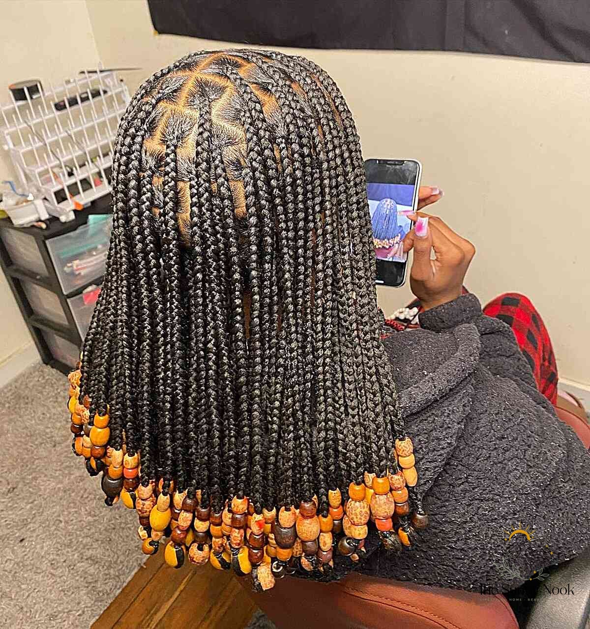 10 Color Knotless Braids for the Ultimate Glow Up 9 Shoulder-Length Black Braids with Orange Beads